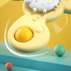 A yellow suction cup spinner bath toy with a white character floating above it, resting on a blue surface.
