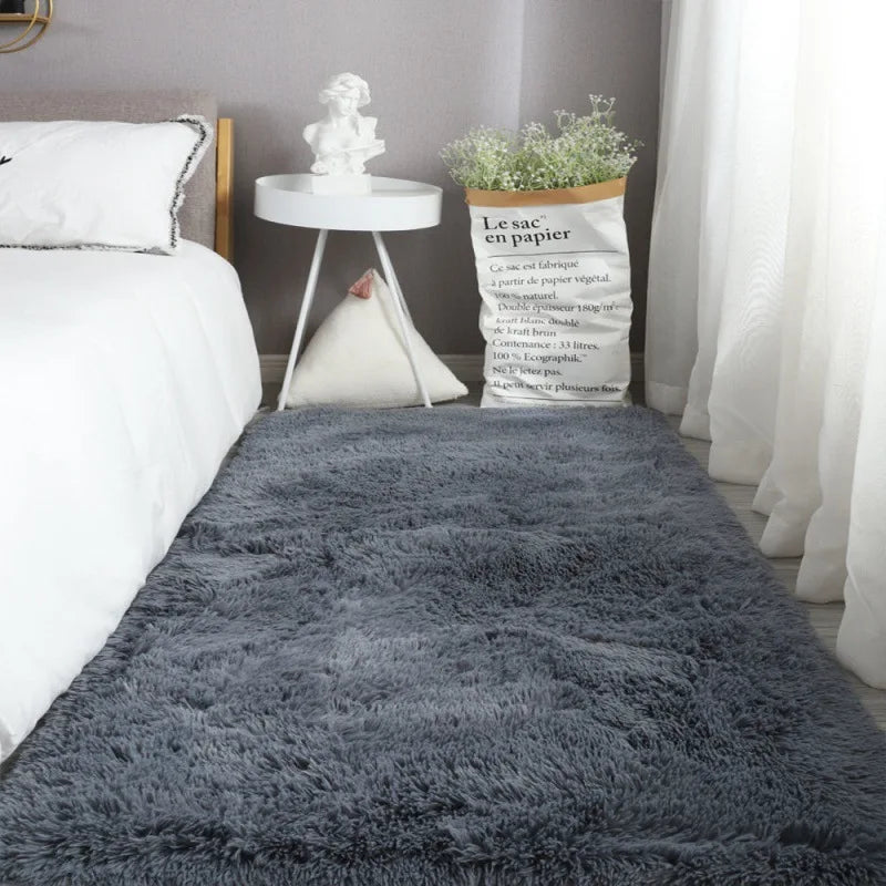 A fluffy gray Nordic fur rug placed on a bed with white linens and decorative elements.