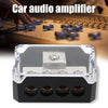 A black plastic car audio amplifier power distribution block with four terminals and a fuse.