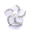 A white flower-shaped button with a pearl center and surrounding clear rhinestones for jewelry making