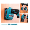 A green and black cordless drill or power tool is shown in various angles, including side hanging on a wooden surface.