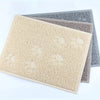 A stack of cat litter mats featuring paw print designs in beige, gray, and blue tones.