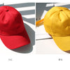 A pair of classic cotton dad hats in red and yellow shown side by side on a white surface.