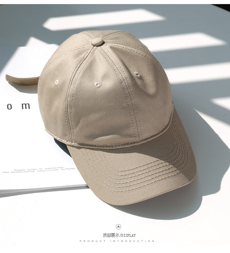 A beige classic cotton dad hat shown in a studio setting with shadows.