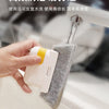 A hand is using a white cleaning brush with a yellow handle to clean window tracks or door sliders.