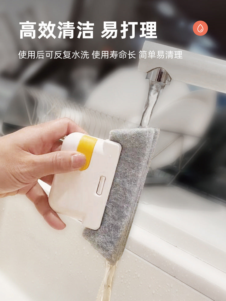 A hand is using a white cleaning brush with a yellow handle to clean window tracks or door sliders.