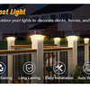 A row of white solar post lights illuminating a wooden fence and patio area at night.