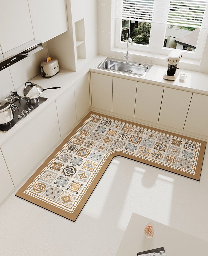 An L-shaped crystal velvet kitchen mat with a patterned design rests on a white countertop near a window.