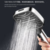 A hand is holding a shower head that is spraying a strong stream of water onto the palm of another hand.