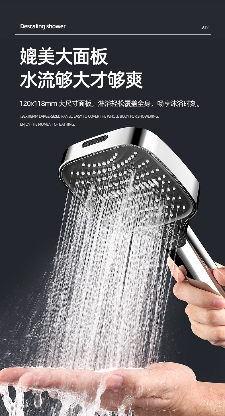 A hand is holding a shower head that is spraying a strong stream of water onto the palm of another hand.