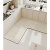 A beige L-shaped kitchen mat with a textured surface and non-slip backing is placed on a light-colored countertop.