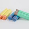 A collection of rolled scented drawstring trash bags in various colors including yellow, orange, blue, and green.