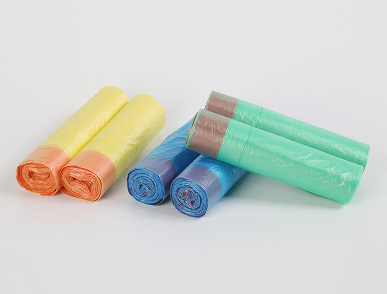 A collection of rolled scented drawstring trash bags in various colors including yellow, orange, blue, and green.