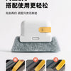 A white cleaning tool with a gold pad rests on a gray felt surface, shown alongside close-ups of the brush and pad.