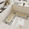 An L-shaped crystal velvet kitchen mat with a black and white patterned border is displayed on a modern kitchen floor.