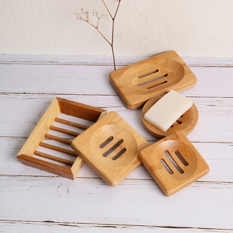 A set of natural bamboo soap dishes with fast-dry drainage and a white bar of soap on a light wooden surface.
