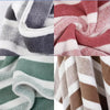 A close-up of a set of soft absorbent quick-dry bath towels in various striped colors including gray, white, pink, and brown.