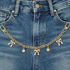 A close-up of a denim jean pocket featuring a gold alloy chain with pearl charms.