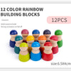 A set of twelve colorful wooden rainbow building blocks in various shades and sizes.