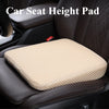 A beige 3D mesh car seat height pad placed on a dark brown leather car seat.