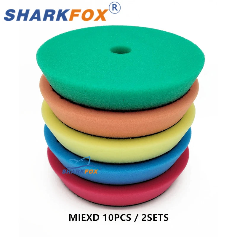 A stack of ten green, orange, yellow, and blue polishing sponge pads for dual-action polishers.