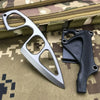A silver compact fixed-blade knife with a black handle is shown resting on a camouflage fabric background.