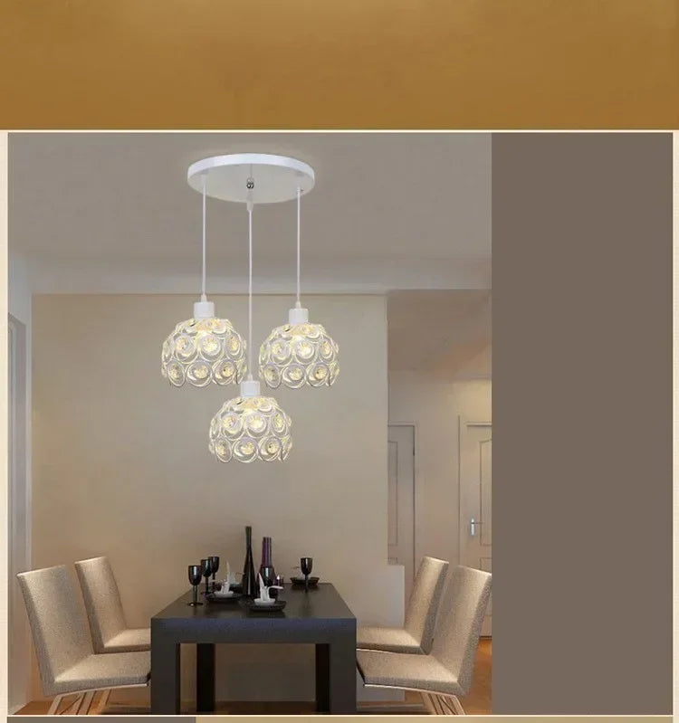 A modern chandelier featuring three crystal glass heads suspended from a ceiling lamp.