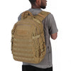 A man is wearing a tan tactical backpack with a MOLLE system and a gray t-shirt.