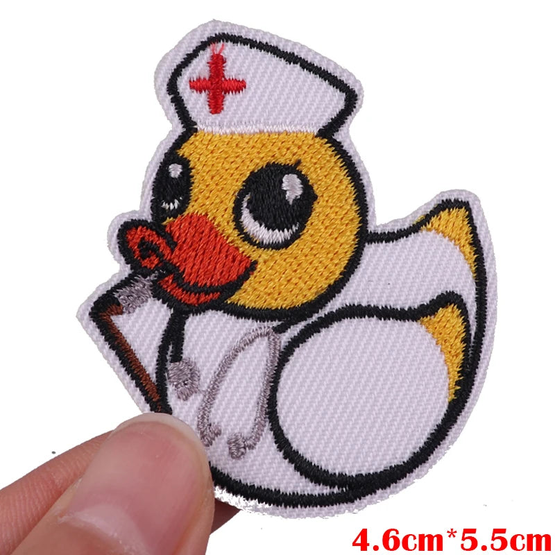 An embroidered patch featuring a yellow duck character wearing a nurse's cap and holding a stick.