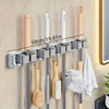 Wall-mounted metal holder for mop and broom with detachable hooks and wooden handles