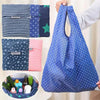 A blue polka dot shopping bag is shown alongside various folded bags in different colors and patterns.