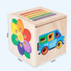 A wooden 5-in-1 Montessori shape and color sorting toy box with colorful wooden shapes and a blue vehicle.