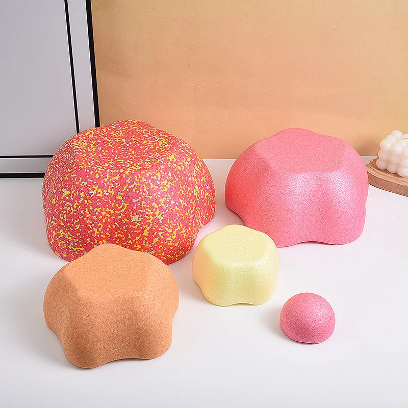 A collection of colorful, soft, foam stepping stones in pink, orange, and yellow for sensory and motor skill development.