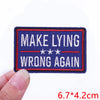A dark blue embroidered iron-on letter patch with red and white text that reads MAKE LYING WRONG AGAIN