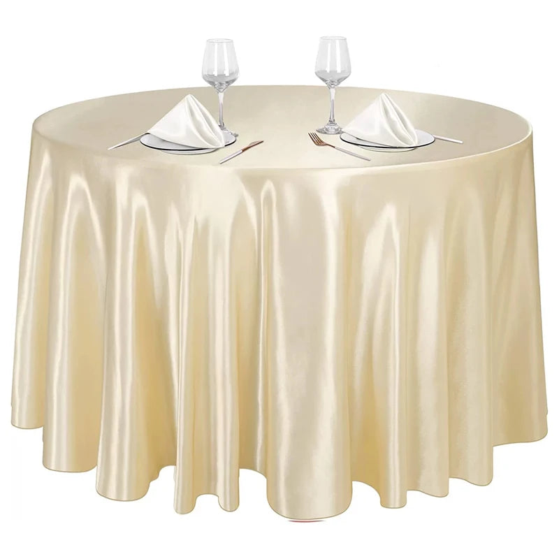 Elegant satin gold round tablecloth set for dining events with glassware and silverware