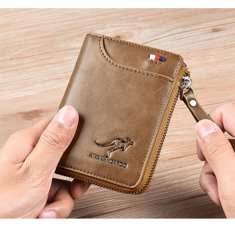 A brown leather wallet with a zipper is being held by a hand on a wooden surface.
