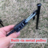 A hand holds a black camping rope tensioner with a built-in metal pulley attached to a black rod.