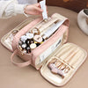 A pink waterproof PU leather cosmetic bag is shown open, filled with various makeup and skincare products, being held by a ha