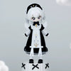 A white-haired doll figurine dressed in a black and white gothic outfit with a hood and wings.