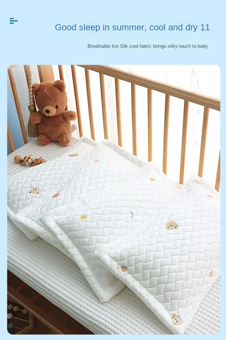 A white quilted baby pillow with a breathable ice silk cover is shown on a wooden crib railing.