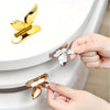 A hand is lifting a gold-colored touch-free toilet seat lifter from a white toilet bowl.