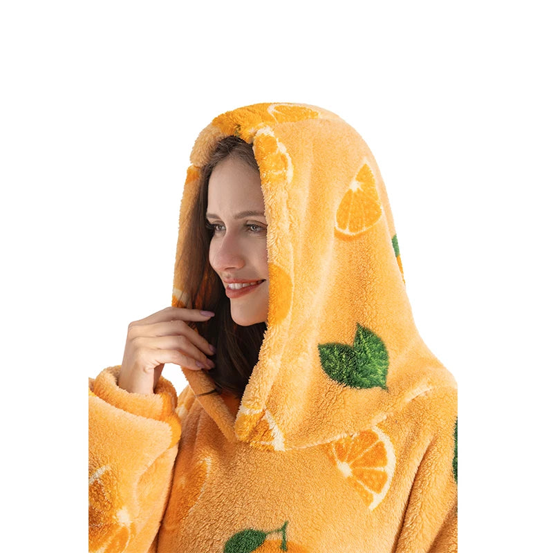 A woman wearing an orange and green patterned fuzzy wearable blanket hoodie.