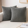 Two gray corduroy throw pillow covers with a textured weave resting on a light-colored sofa.