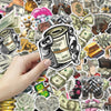 A hand holds a sticker pack featuring various funny money and cartoon graffiti designs.