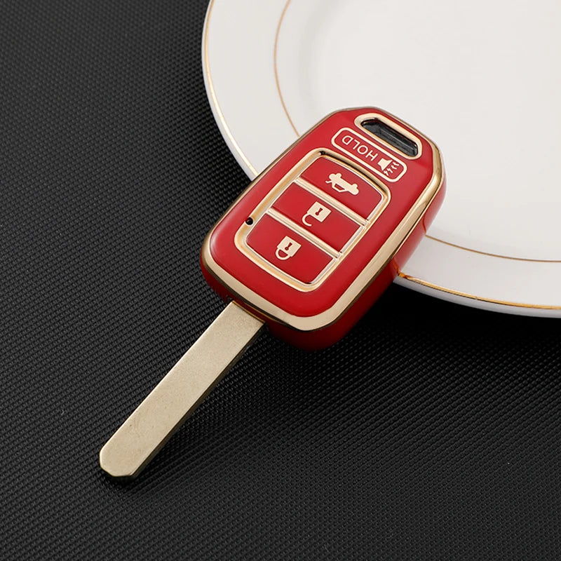 A red TPU key fob cover with a metal blade is placed on a white plate.