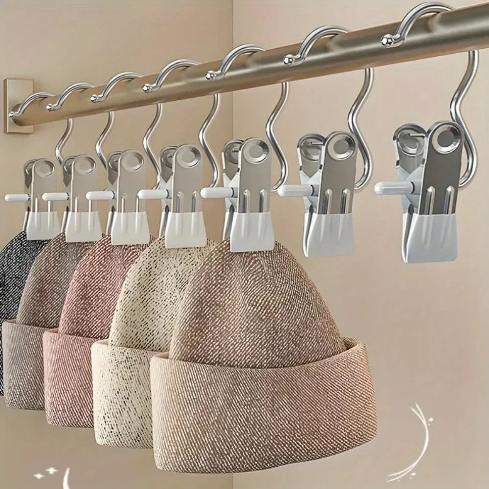 A row of heavy-duty metal hangers with various sized white plastic clips are hanging from a wooden bar.