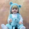 A baby doll wearing a light blue animal hood and holding a matching blue stuffed animal.