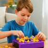 A young boy is playing with a purple shape matching puzzle game, assembling yellow pieces on a wooden table.