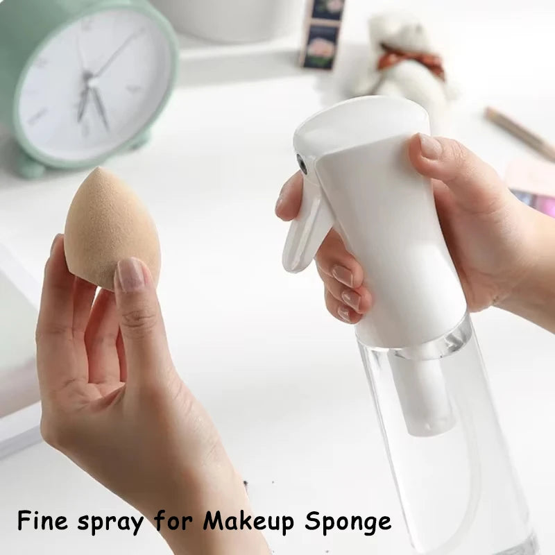 Hands are using a white fine spray bottle to mist a makeup sponge.