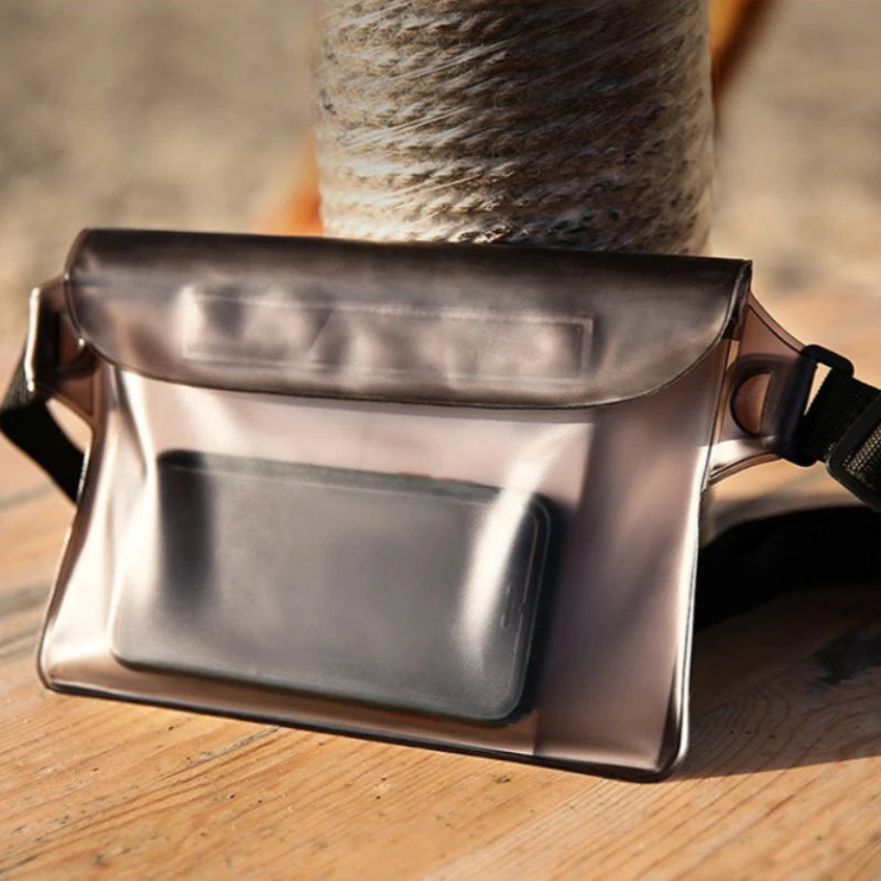 A sleek, metallic silver waterproof phone pouch is shown resting on a wooden surface next to a spool of twine.